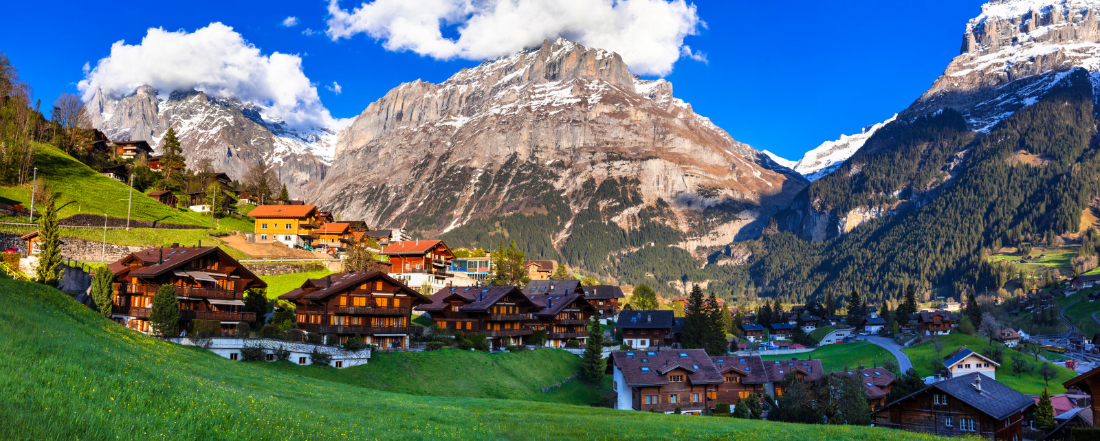 Ein Dorf in den Alpen mit einem großen Berg im Hintergrund